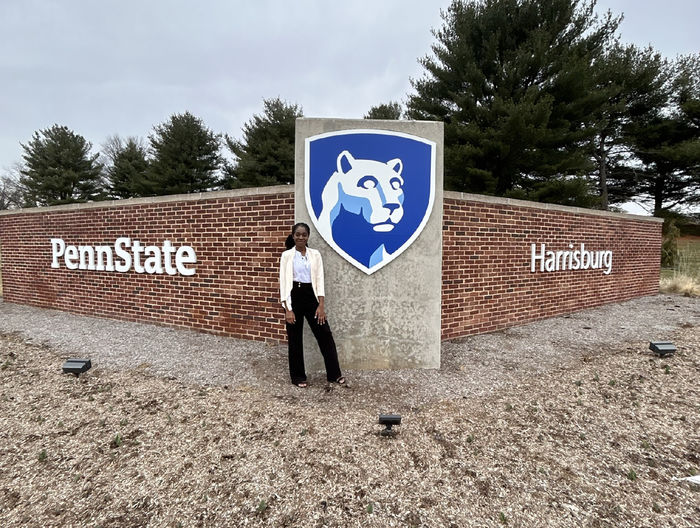 Mary Odei stands in front of the Penn State Harrisburg sign