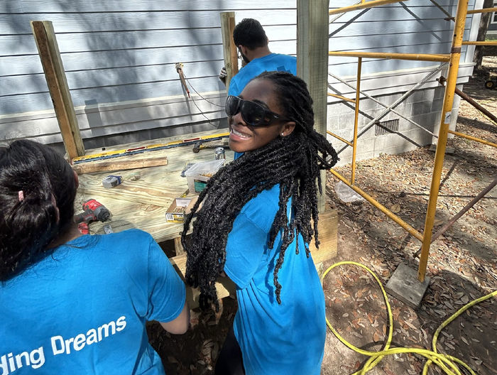 Mary Odei, wearing sunglasses, helps at a Habitat for Humanity site