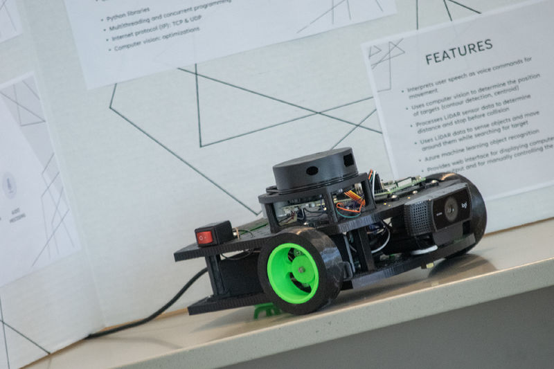 Photo of a voice-controlled robot sitting in front of a research poster