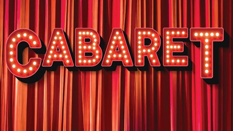Red marquee letters spelling the word Cabaret in front of a red pleated stage curtain