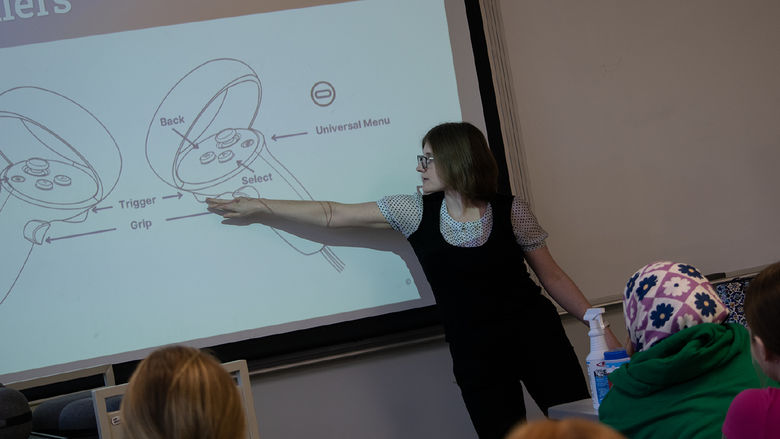 Sarah Kettell, programmer/analyst with the Center for Teaching Excellence at Penn State Harrisburg, points at a screen showing a diagram of virtual reality controllers.