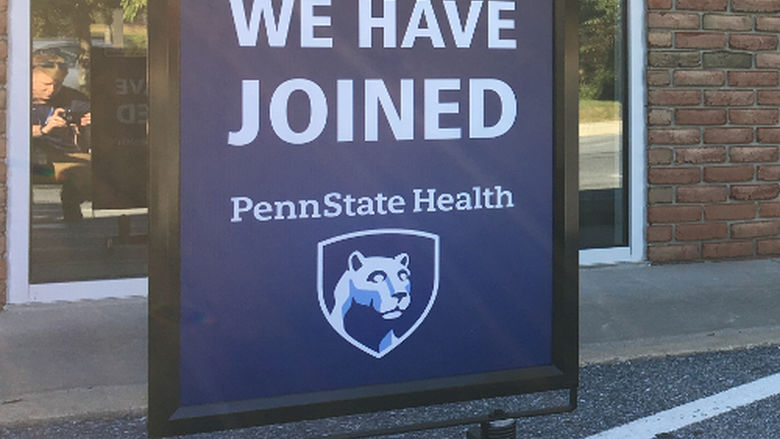 A sign reading "We have joined Penn State Health" sits in front of a brick building labeled "Cornerstone Family Health Associates."