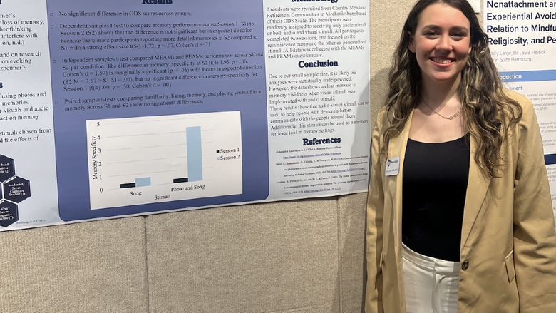 Carolina Hernandez stands with a research poster