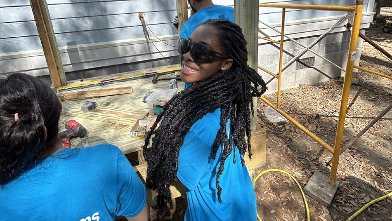 Mary Odei, wearing sunglasses, helps at a Habitat for Humanity site