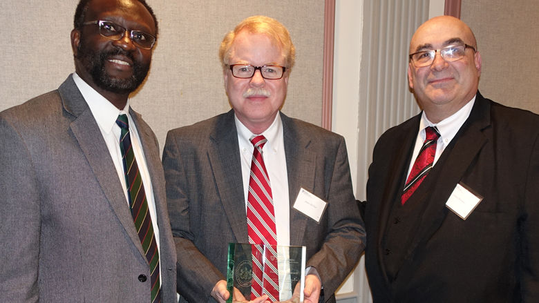 James McClure (center) pictured with Dr. Peter Idowu (left) and Dr. Simon Bronner (right).