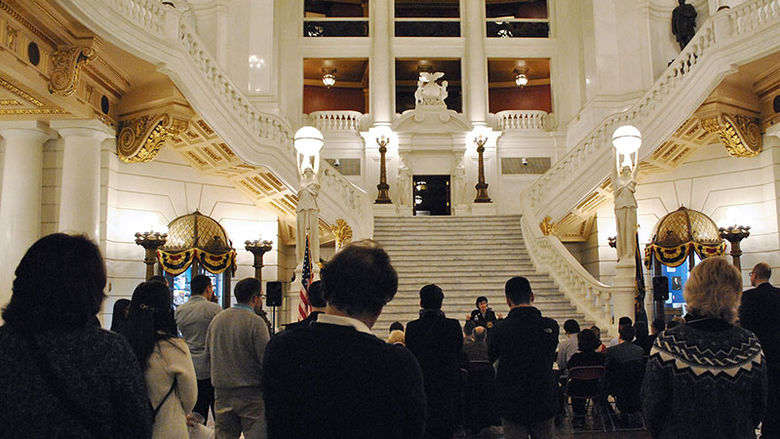 A speaker addresses at crowd in the Capitol Rotunda in nearby Harrisburg