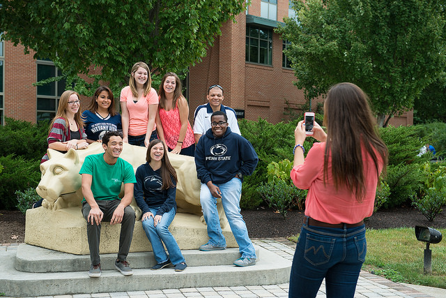 New students taking a picture with the Nittany lion statue in front of PSU Harrisburg Library.