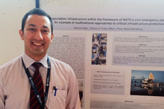 A graduate student in front of his  poster