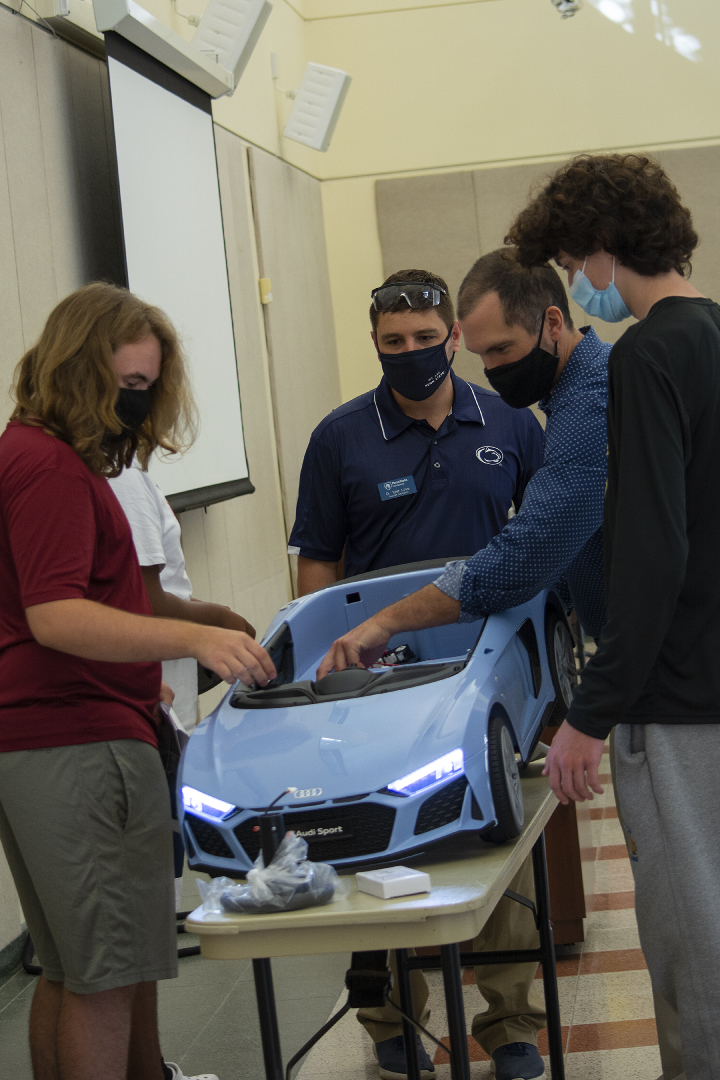 two students and two faculty members construct car