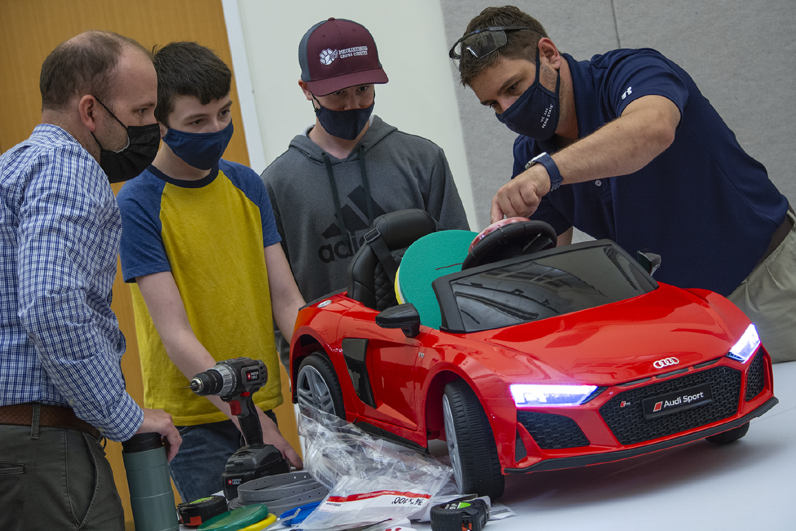 Tyler  Love and Tyler Richardson help two students modify cars