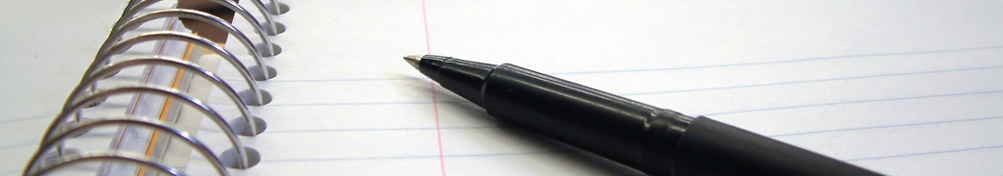 Uncapped pen atop a fresh sheet of spiral bound notebook paper