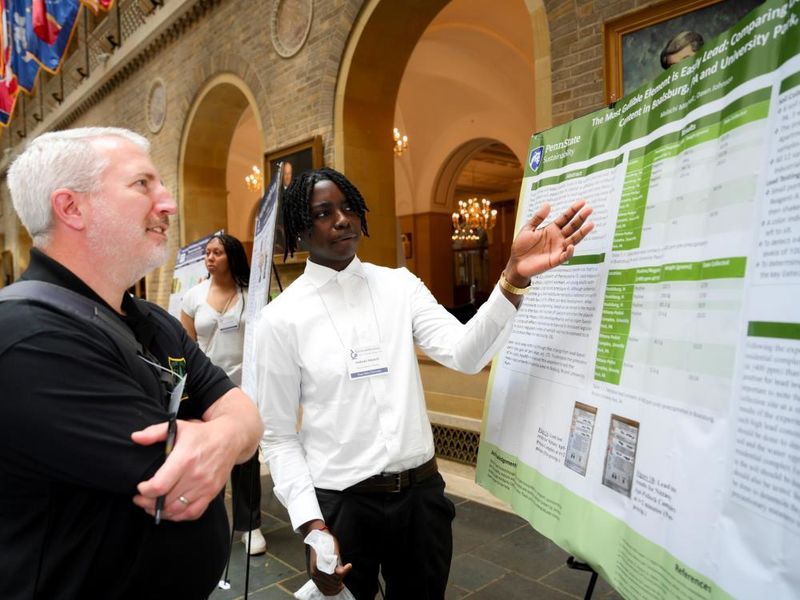 A student presents a scientific poster to a person