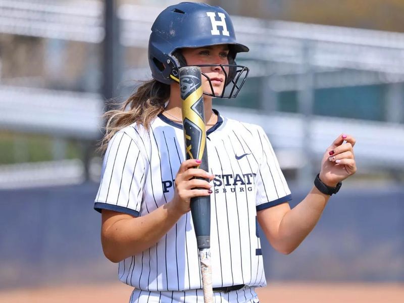 Madelyn Lehigh in a softball uniform holding a bat
