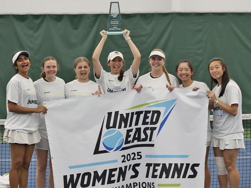 A group of women holding a banner that says United East 2025 women's tennis champions