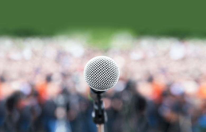 microphone in focus in front of a crowd