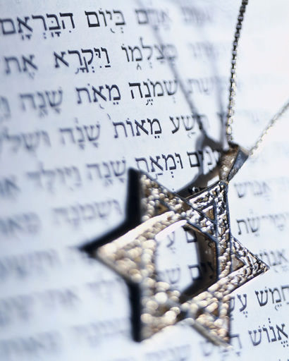 Star of David pendant in front of Hebrew text