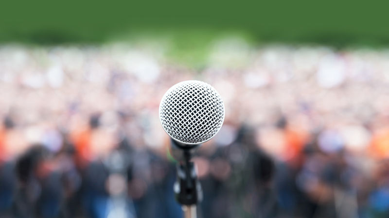 microphone in focus in front of a crowd