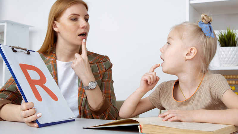 female teacher teaching speech to female student