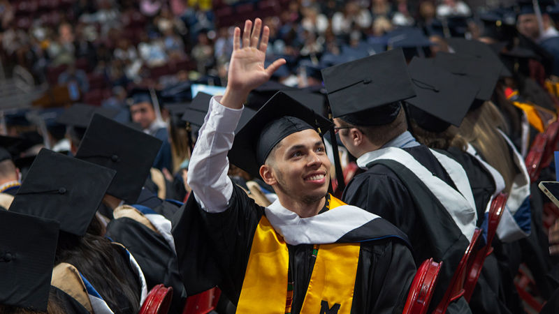 New Penn State Harrisburg graduate waves to his family at Commencement ceremony