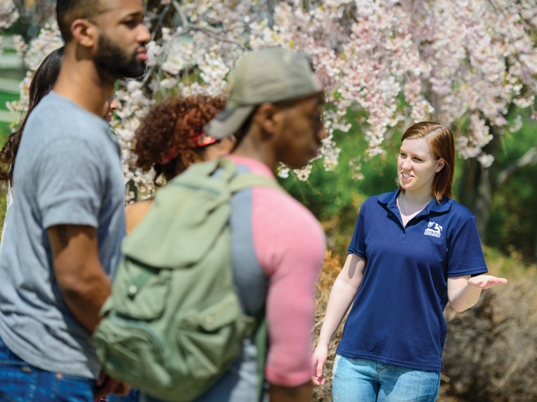 A Penn State tour guide shows a group of prospective students around campus