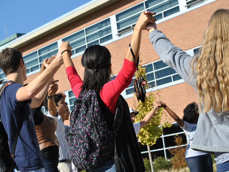 college students of various ethnicities holding hands as a sign of diversity and unity