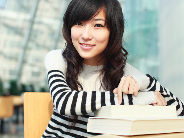 student with a stack of textbooks