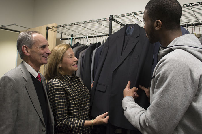 Chancellor Mason and Wife with Student looking at suit