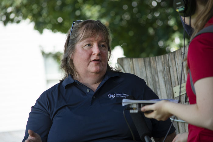 Shirley Clark, wearing a Penn State Harrisburg shirt, speaks with a reporter outdoors