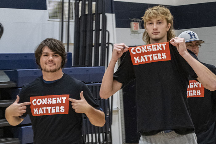 Two students wear black shirts featuring the words "Consent Matters" in a red box