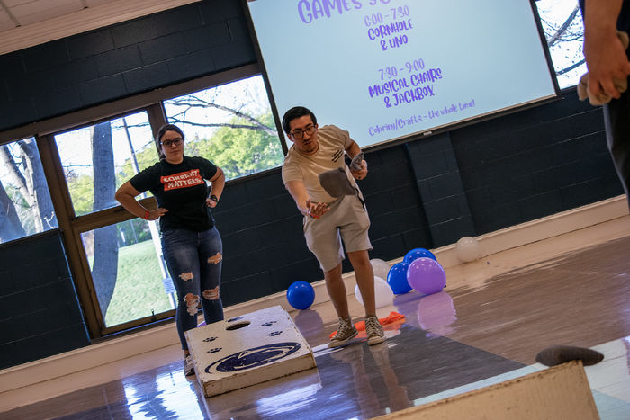 Photo of two students playing cornhole during a game night fundraiser held in the Capital Union Building at Penn State Harrisburg
