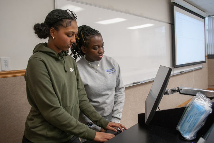 High school student Sarah Gebrezgi and her undergraduate mentor Chelsy-Sippora Funebe look at a computer screen together during an EnvironMentors meeting
