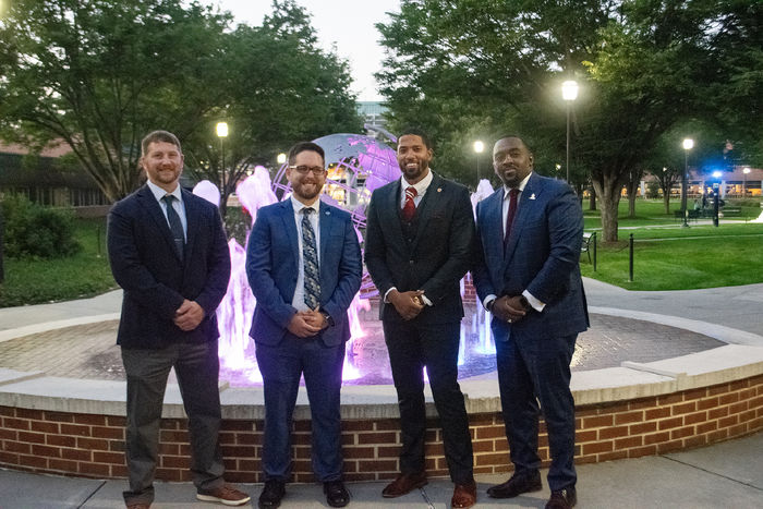 Four recipients of the People to Watch Award gather by the fountain at Penn State Harrisburg