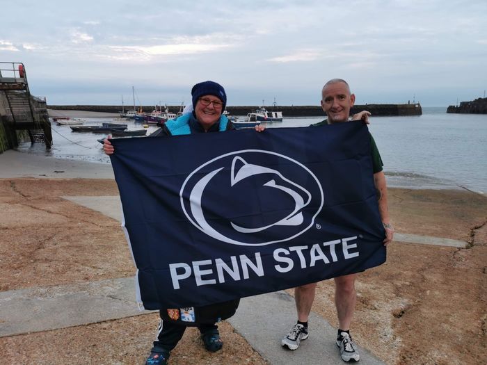 Mckenna and husband holding Penn State Banner