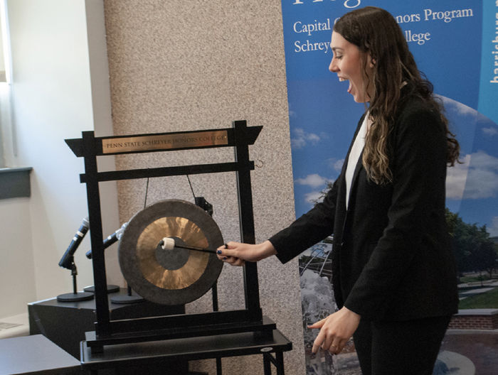Carolina Hernandez rings the gong during an honors ceremony