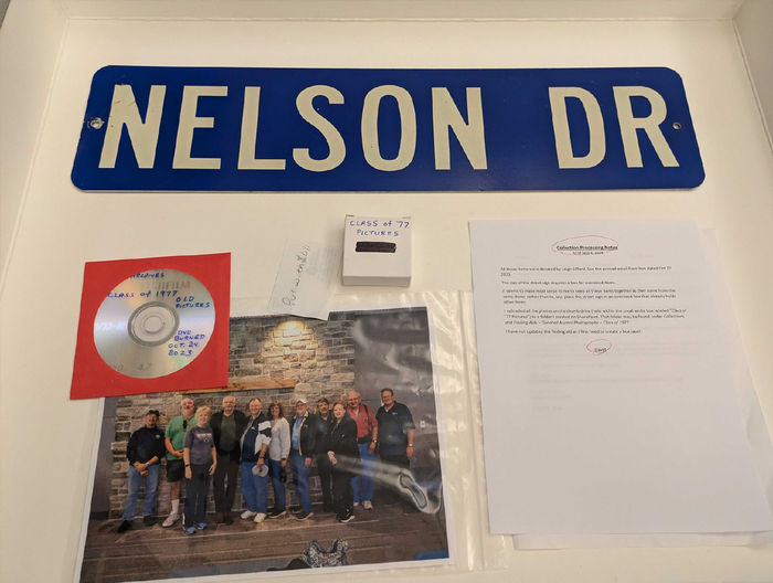 Photo of a road sign that says Nelson Dr, a photo of Penn State Harrisburg alumni, and a dvd of photos