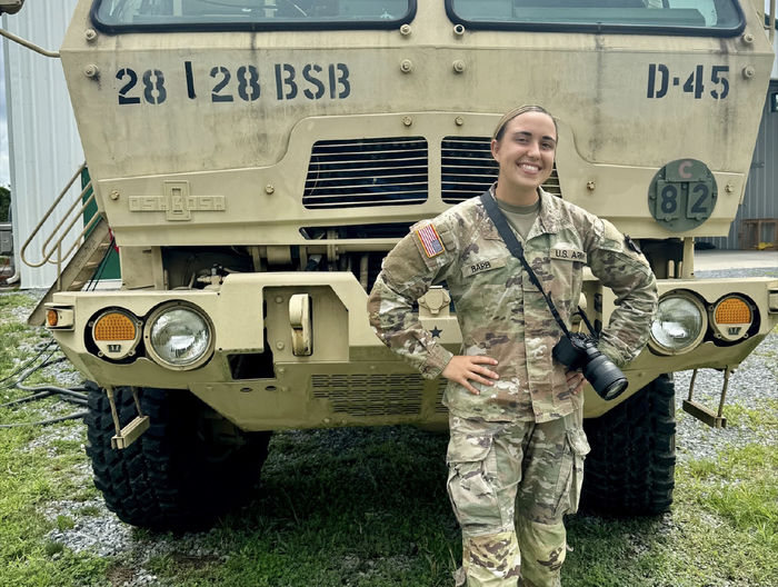 Jessica Barb stands in front of a military vehicle