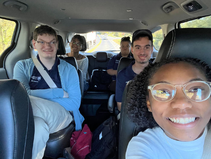 Selfie of a woman in the front seat of a car, with four people in the back seats
