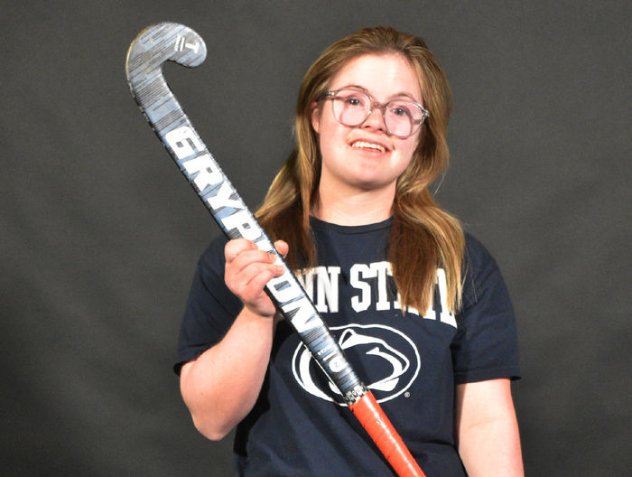 Maggie Kutz poses holding a field hockey stick