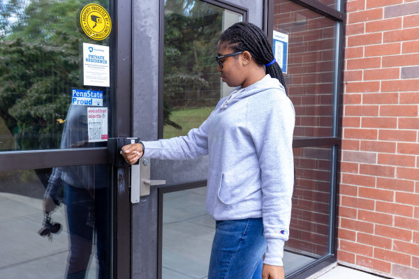 a Penn State student unlocks a door with mobile id+ on her smartwatch