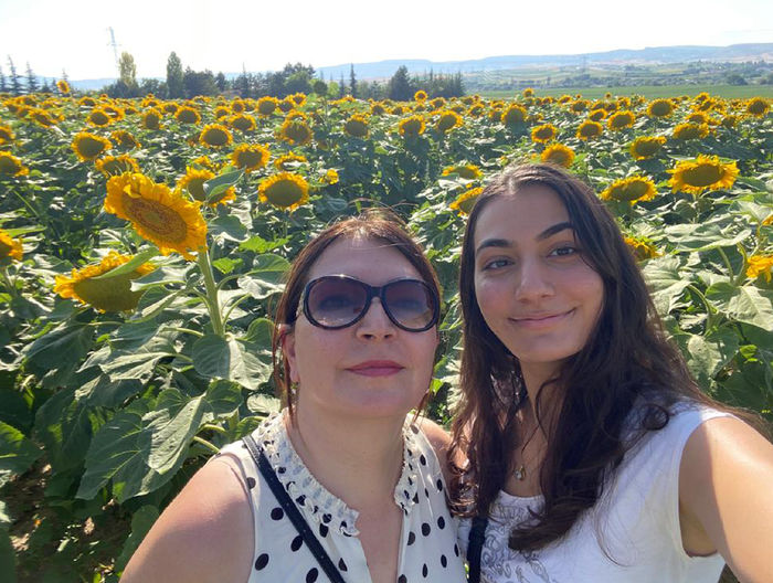 Senel Poyrazli and Dilan Kucukaydin in field of sunflowers.