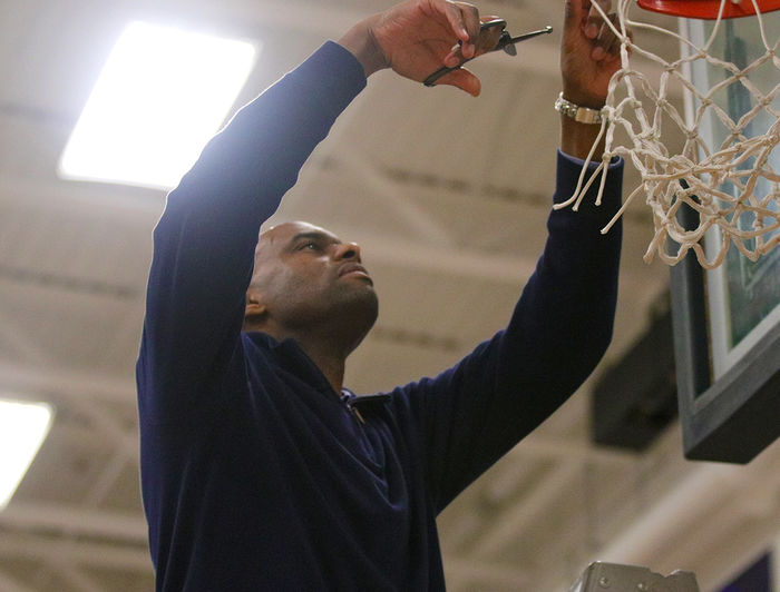 Rahsaan Carlton cuts down piece of basketball net