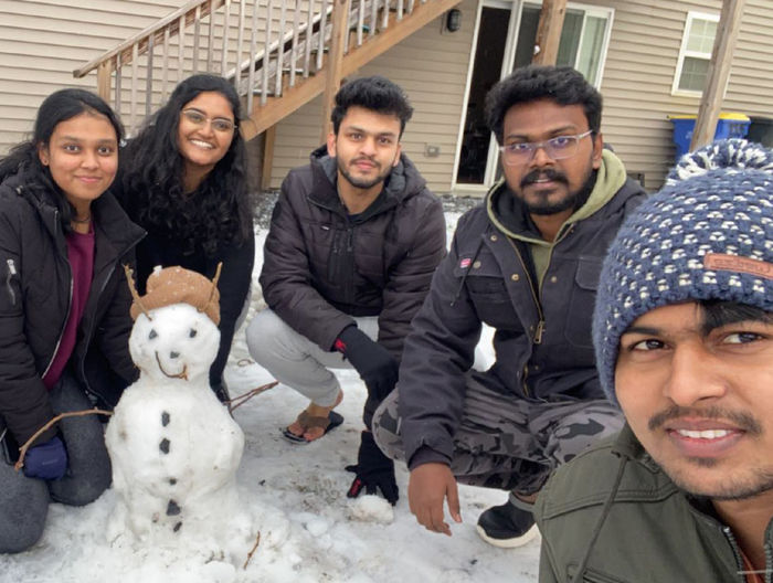Patel and four friends with a small snowman they made
