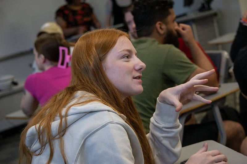 A student talks with a group about using virtual reality headsets