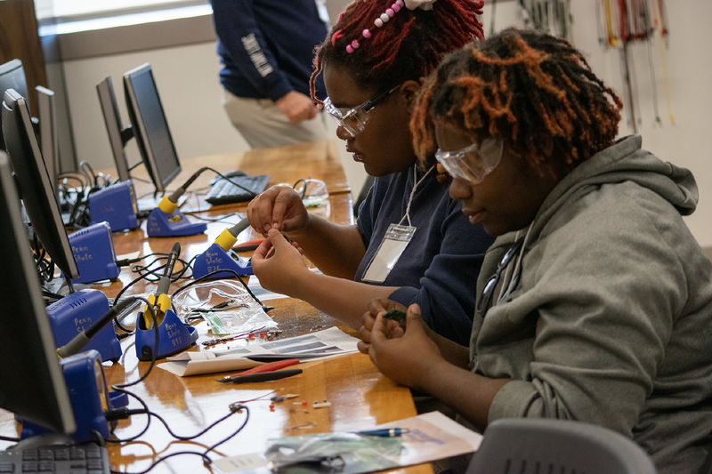 Two high school students work on a soldering activity