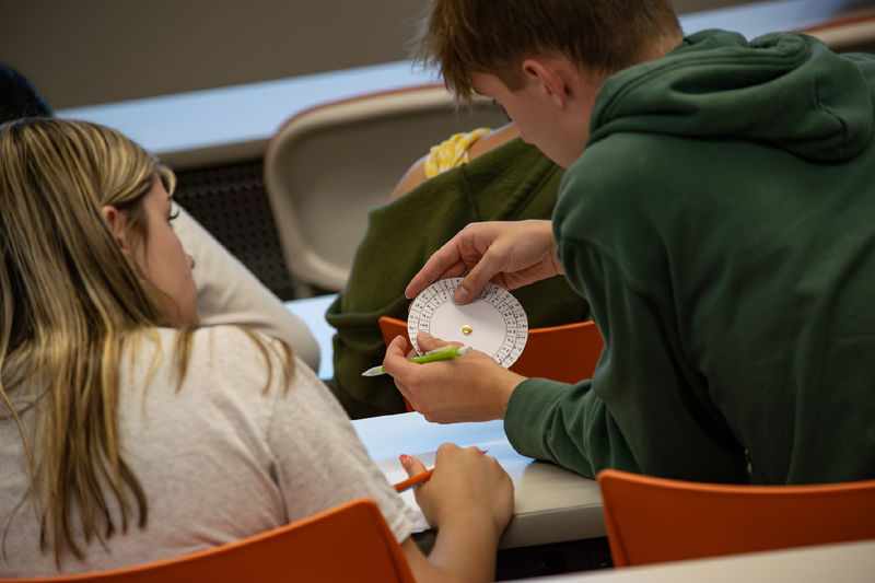 Students look at a cipher wheel during a STEM activity