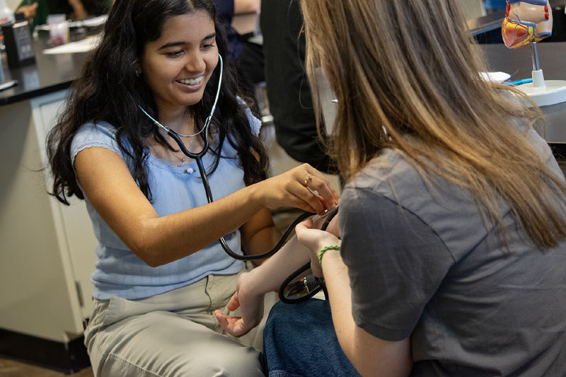 High School students listen with stethoscopes during an activity