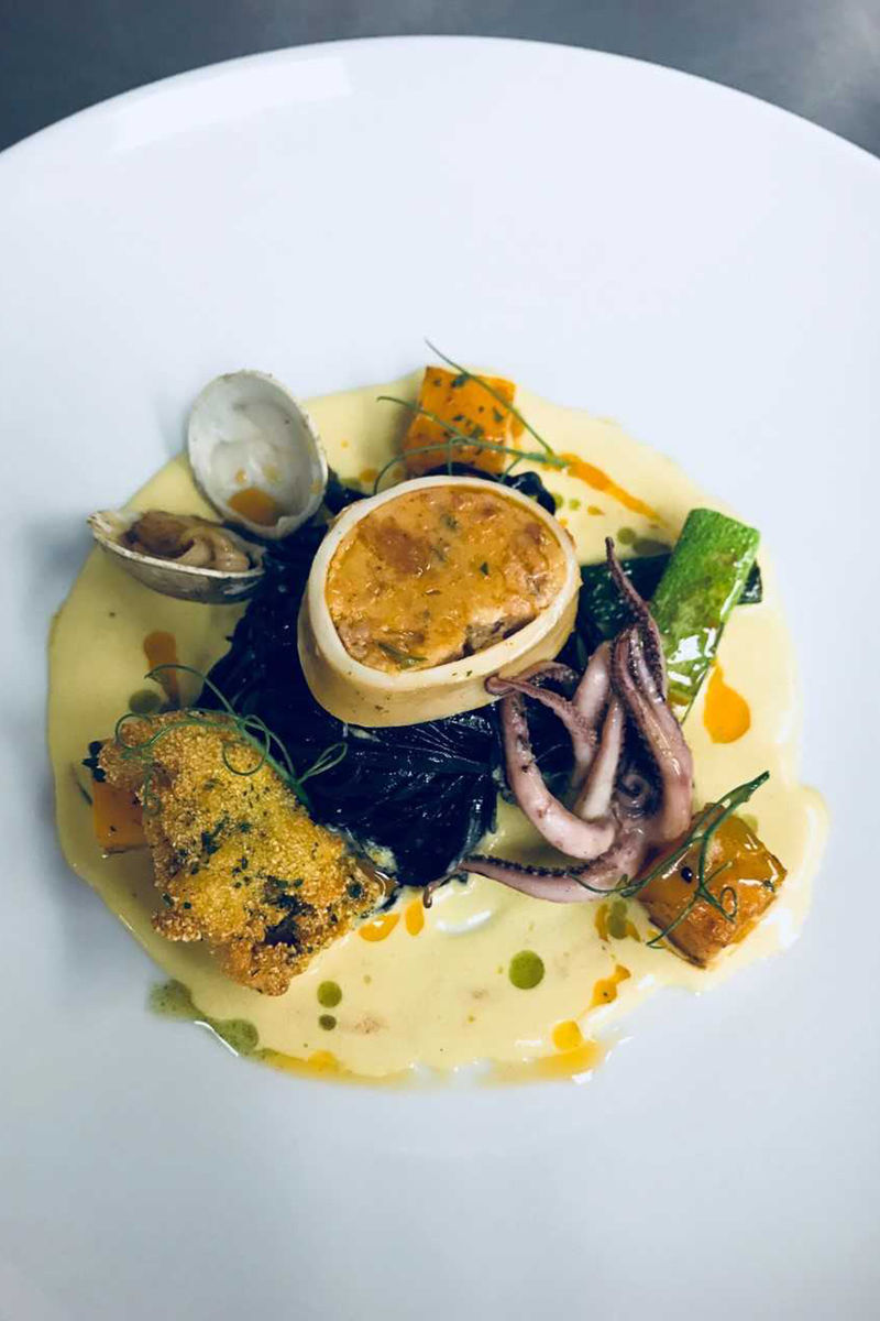 squid ink pasta with crispy Rhode Island oyster, poached squid sausage, sautéed curry clam, batonnet zucchini, and pan roasted butternut squash in a saffron cream sauce 
