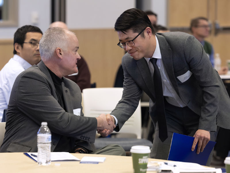 Sung Choi, right, shakes hands with Doug Leslie