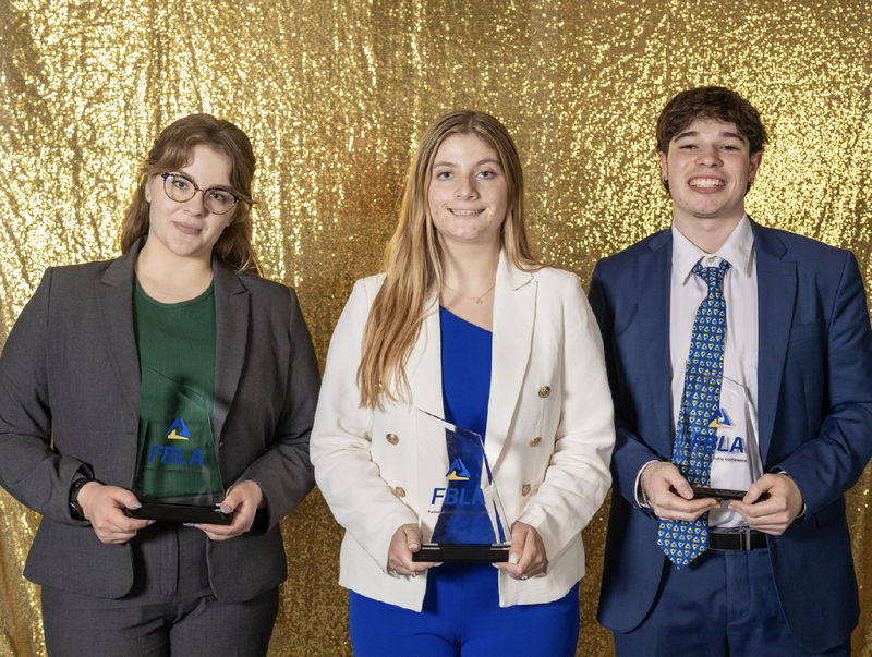 Three students hold FBLA trophies