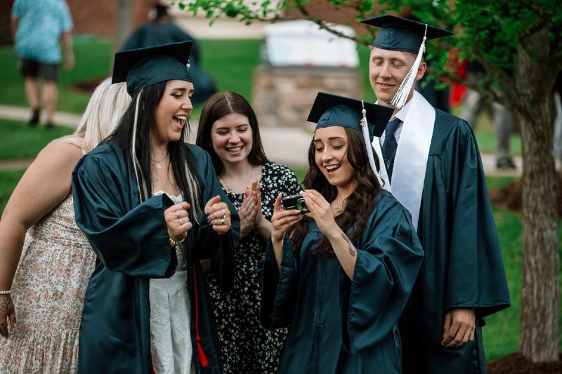 Graduates and students gather to look at camera photo